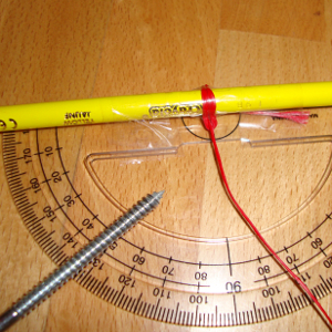 Experiment 27, Bild 3: Den Breitengrad bestimmen mit Winkelmesser, Schnur, Bleistift, Tesafilm, Schraube und Polarstern. Den Bleistift am Winkelmesser befestigen.
