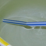Experiment 28, Bild 2: Was ist Brechung? Strohalm im Wasser sieht geknickt aus (Nahaufnahme).